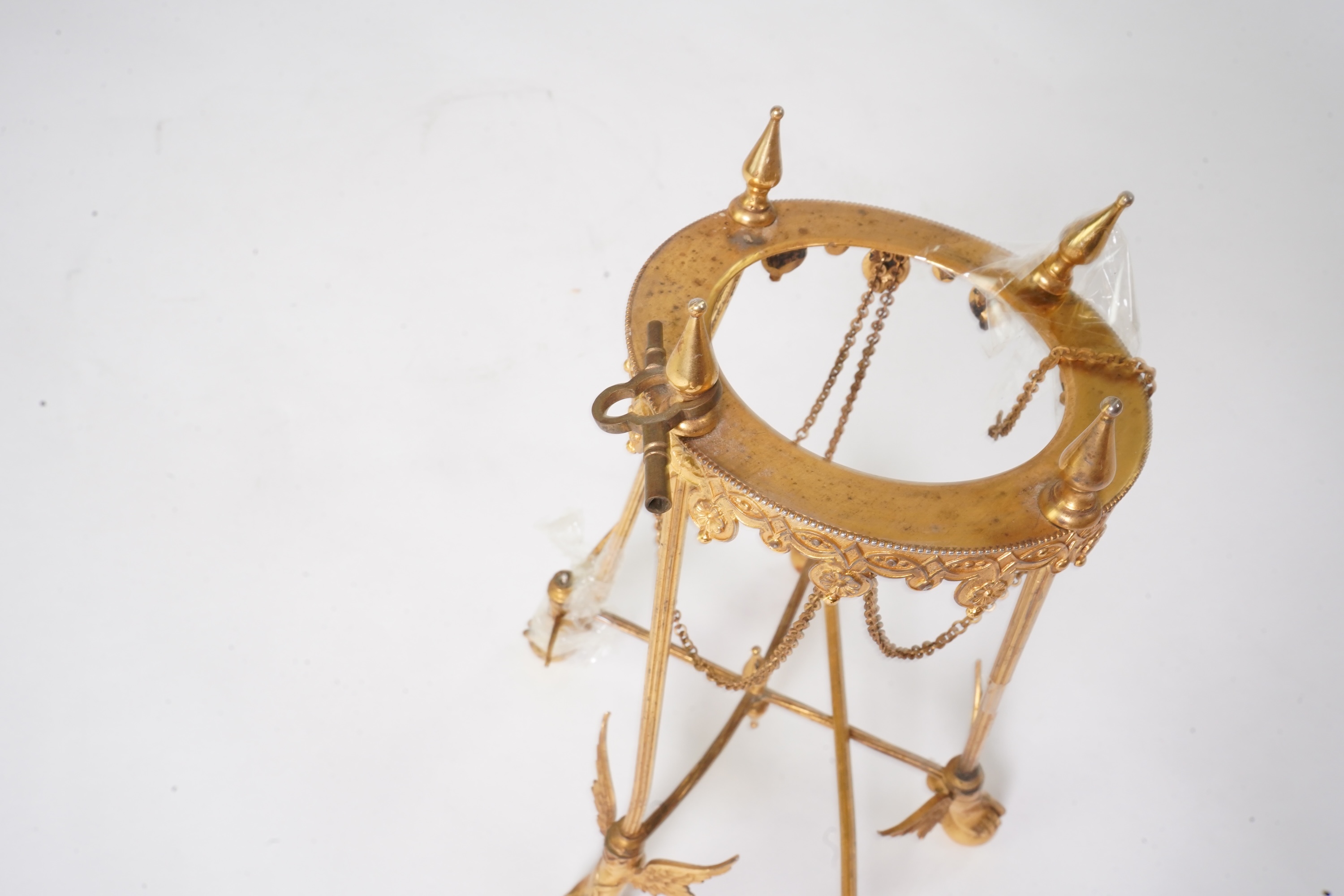 An unusual enamel and gilt brass timepiece, pendant from gilt brass frame, stand 26cm high. Condition - dismantled